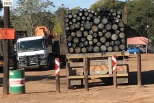 Truck loads of creosote treated poles leaving customer facility